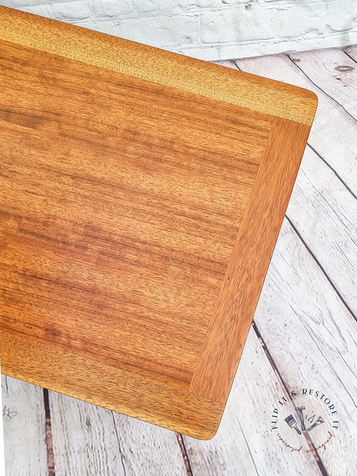 A G-Plan Librenza Mid Century Modern Black and Tola Vintage Coffee Table from the 1950's is set against a distressed white wooden floor and a white brick background. The logo and text "Find it Restore it" are visible in the lower right corner.